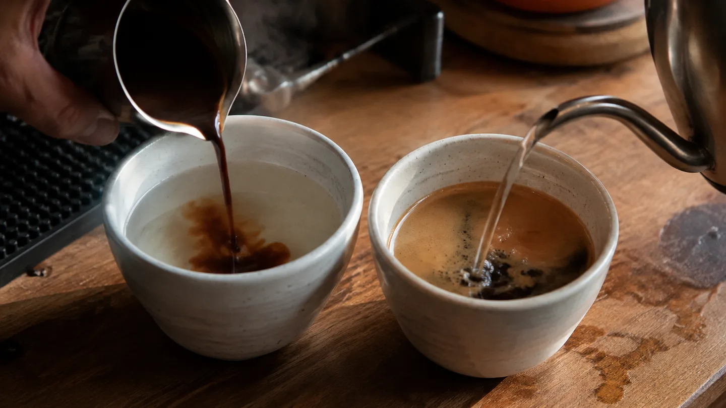 Two cups show different ways to combine espresso and hot water at a home coffee bar.