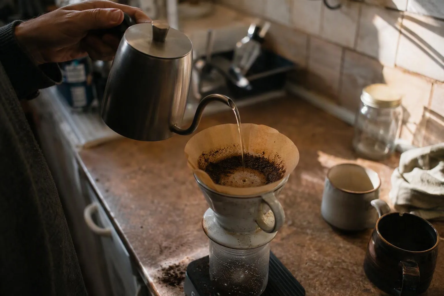 Fine grounds gather along the paper filter as a slow pour settles the coffee bed.